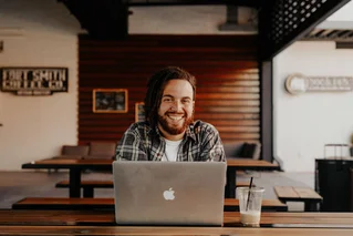 man looking up from computer smiling